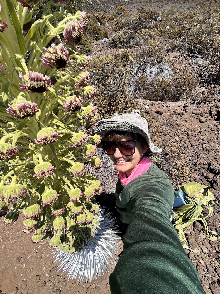 Ariel smiling next to an 'ahinahina plant, also known at the Hawai'i silversword.