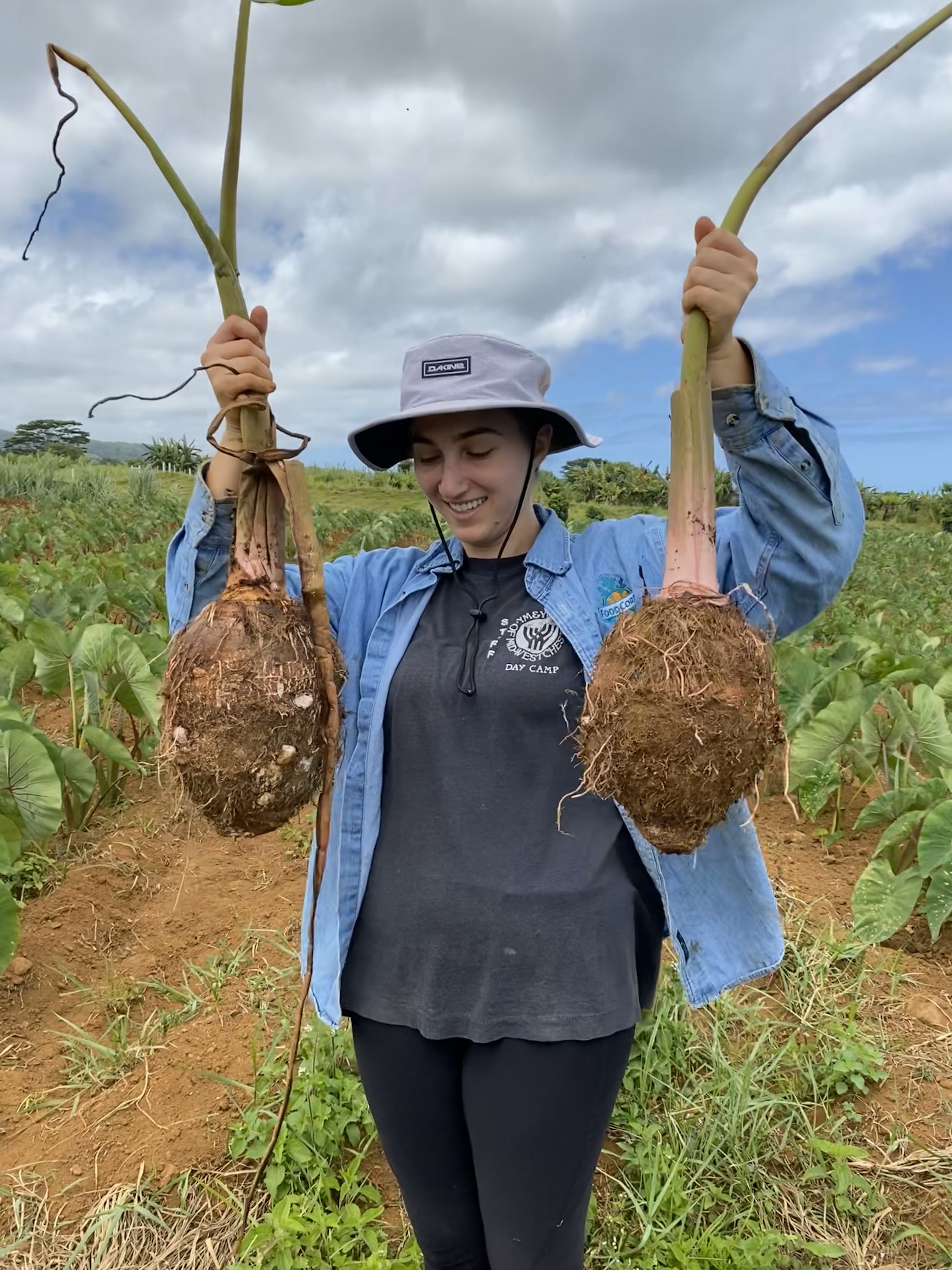 Anna stands on a farm holding two giant Kalo
