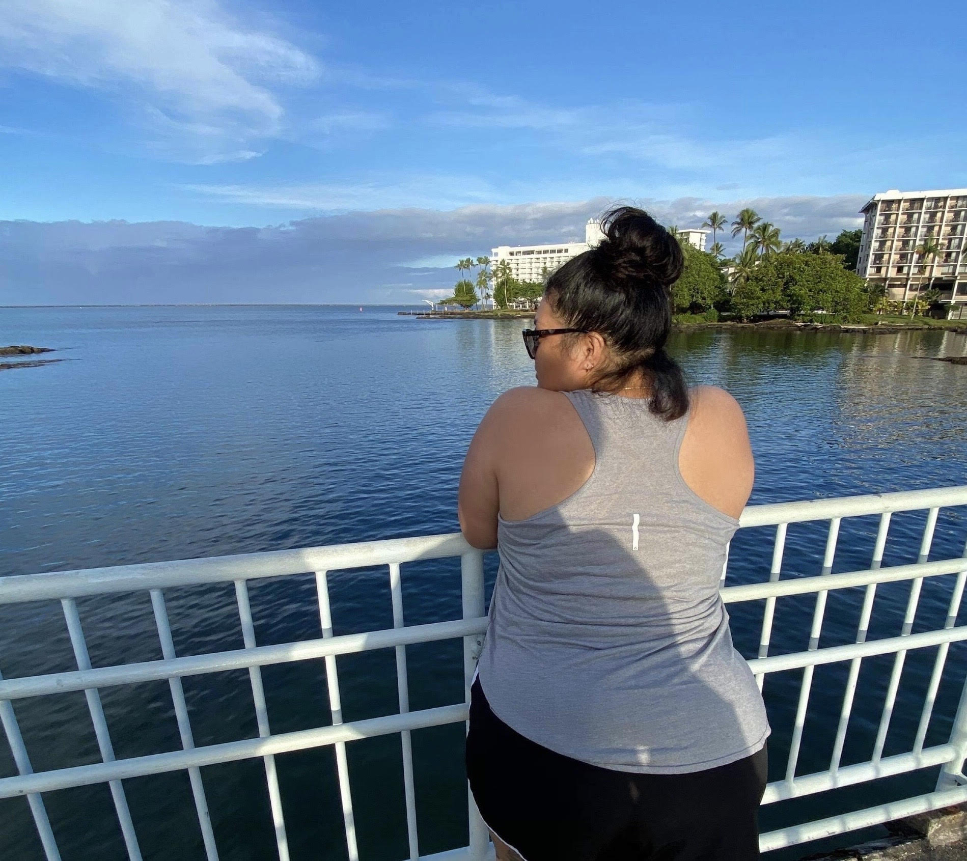 Tearina stands on a bridge looking out at the water