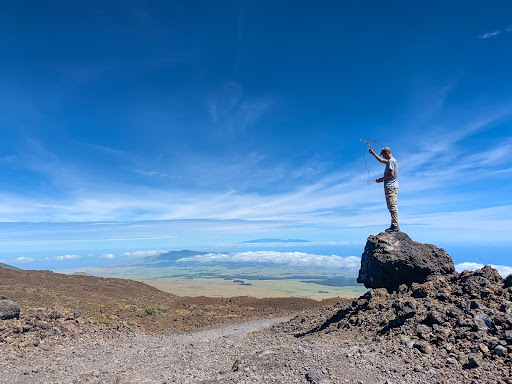 A student on a puʻu with telemetry tracking equipment