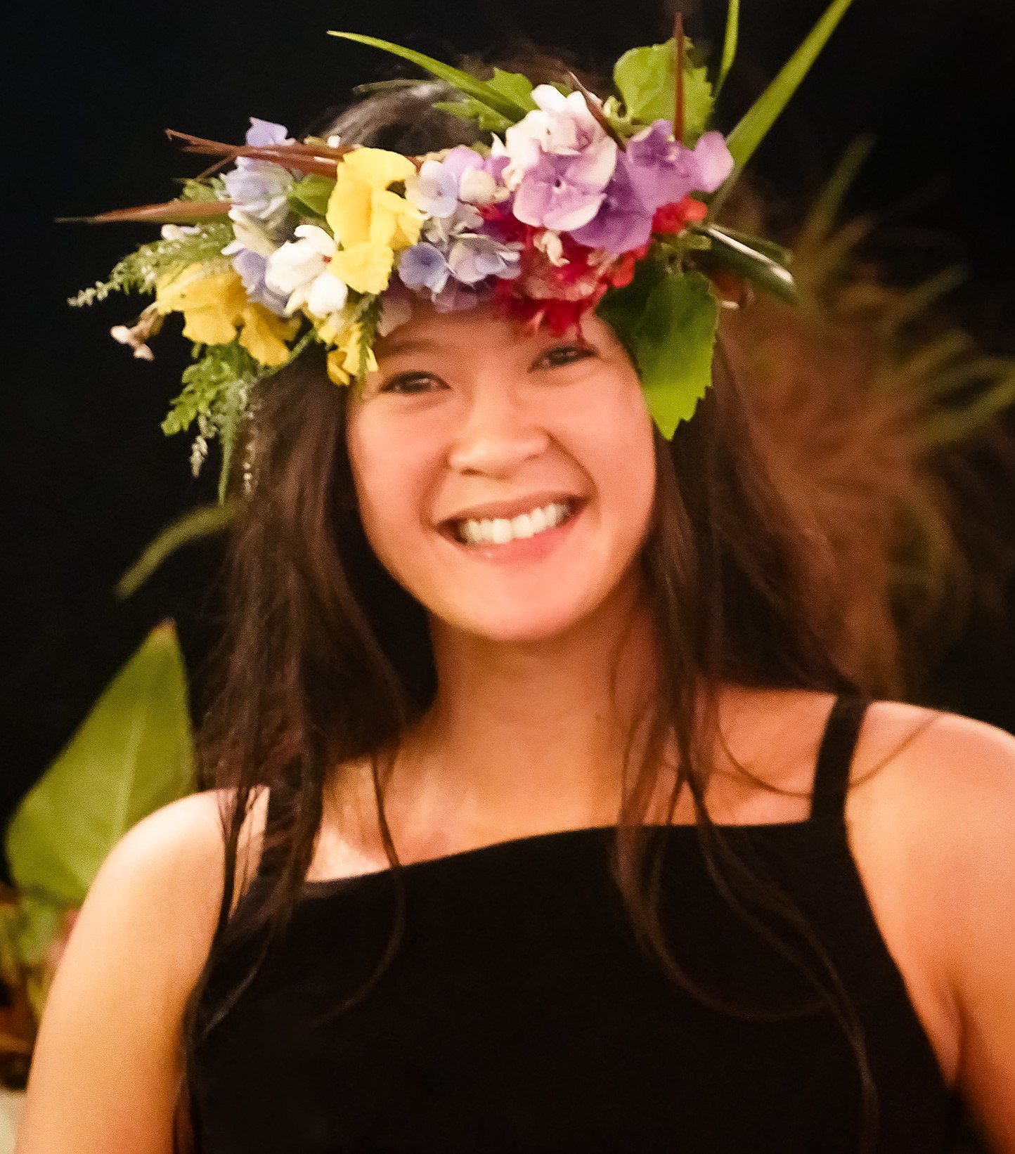 Headshot of Erica wearing a flower lei on her head